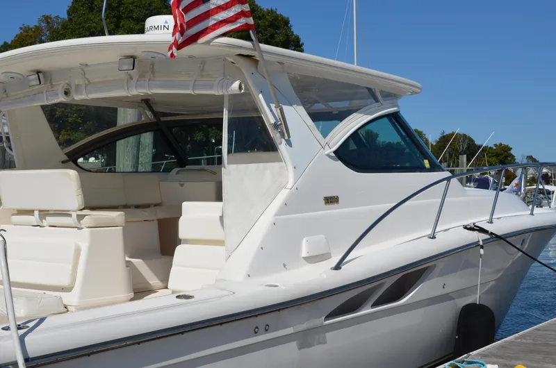 Slide: The Image of 2004 Tiara Yachts 3800 Open docked, featuring sleek design and spacious seating area. - 8