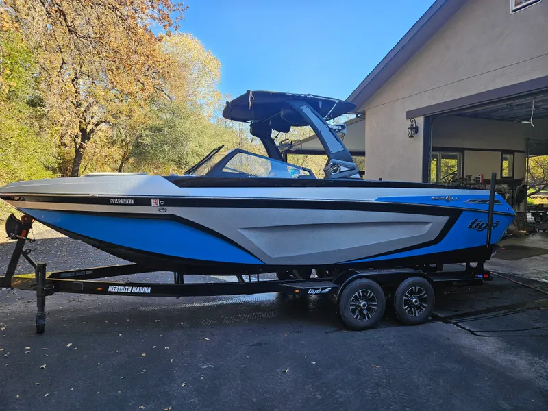 Slide: The Image of 2020 Tigé 25ZX boat in driveway, blue and gray design, on trailer. - 23