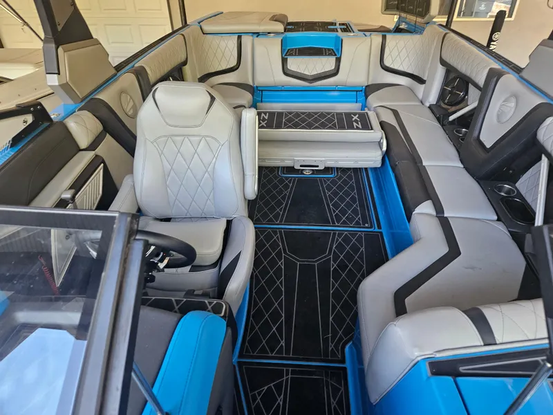 Slide: The Image of 2020 Tigé 25ZX boat interior with blue and gray seating, modern design, and spacious layout. - 32