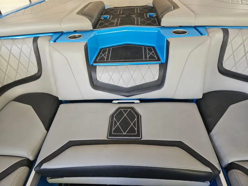 Slide: The Image of 2020 Tigé 25ZX boat interior with gray and blue seating, diamond stitching, and cup holders. - 38