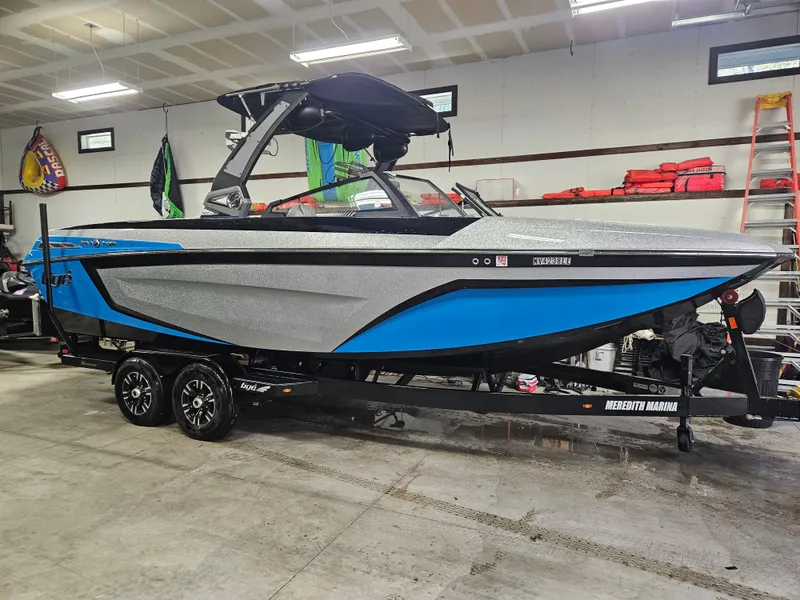 Slide: The Image of 2020 Tigé 25ZX boat in garage, blue and gray design, on trailer. - 46