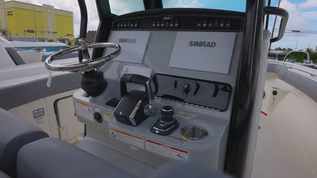 Slide: The Image of 2025 Boston Whaler 280 Outrage helm with Simrad electronics and modern controls. - 12