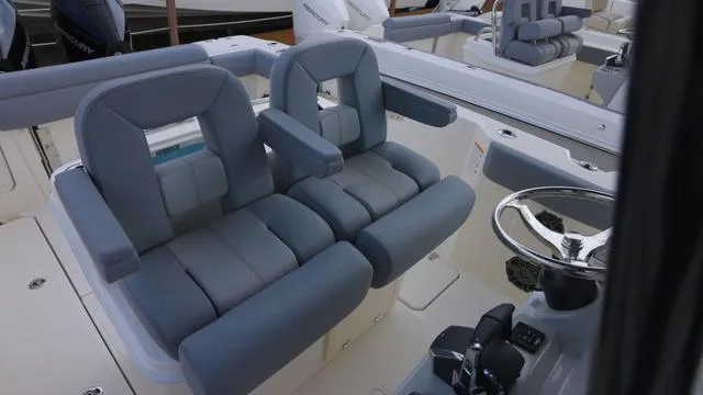 Slide: The Image of 2025 Boston Whaler 280 Outrage boat interior with dual cushioned seats and steering wheel. - 15