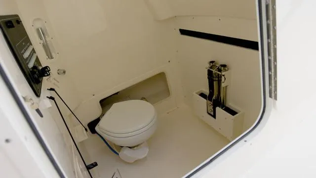 Slide: The Image of 2025 Boston Whaler 280 Outrage boat interior with compact marine toilet. - 17