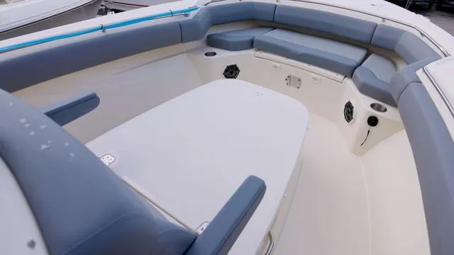 Slide: The Image of 2025 Boston Whaler 280 Outrage boat interior with cushioned seating and spacious layout. - 18
