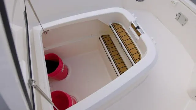 Slide: The Image of Storage compartment on 2025 Boston Whaler 280 Outrage boat with red buckets. - 21