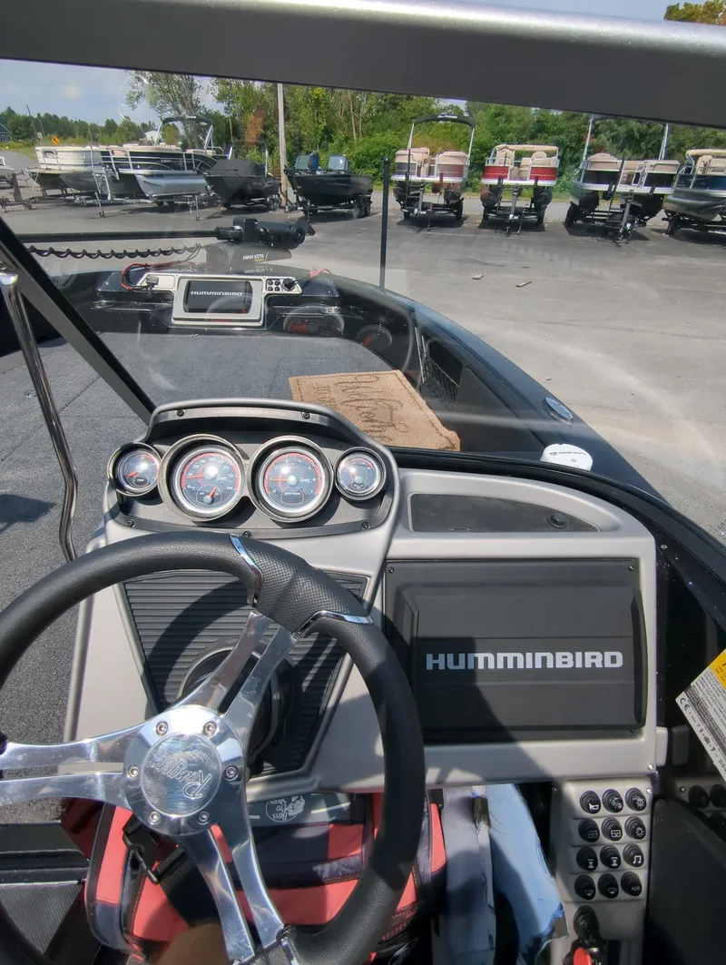 Slide: The Image of 2023 Ranger 2080MS boat dashboard with Humminbird electronics in a marina setting. - 11