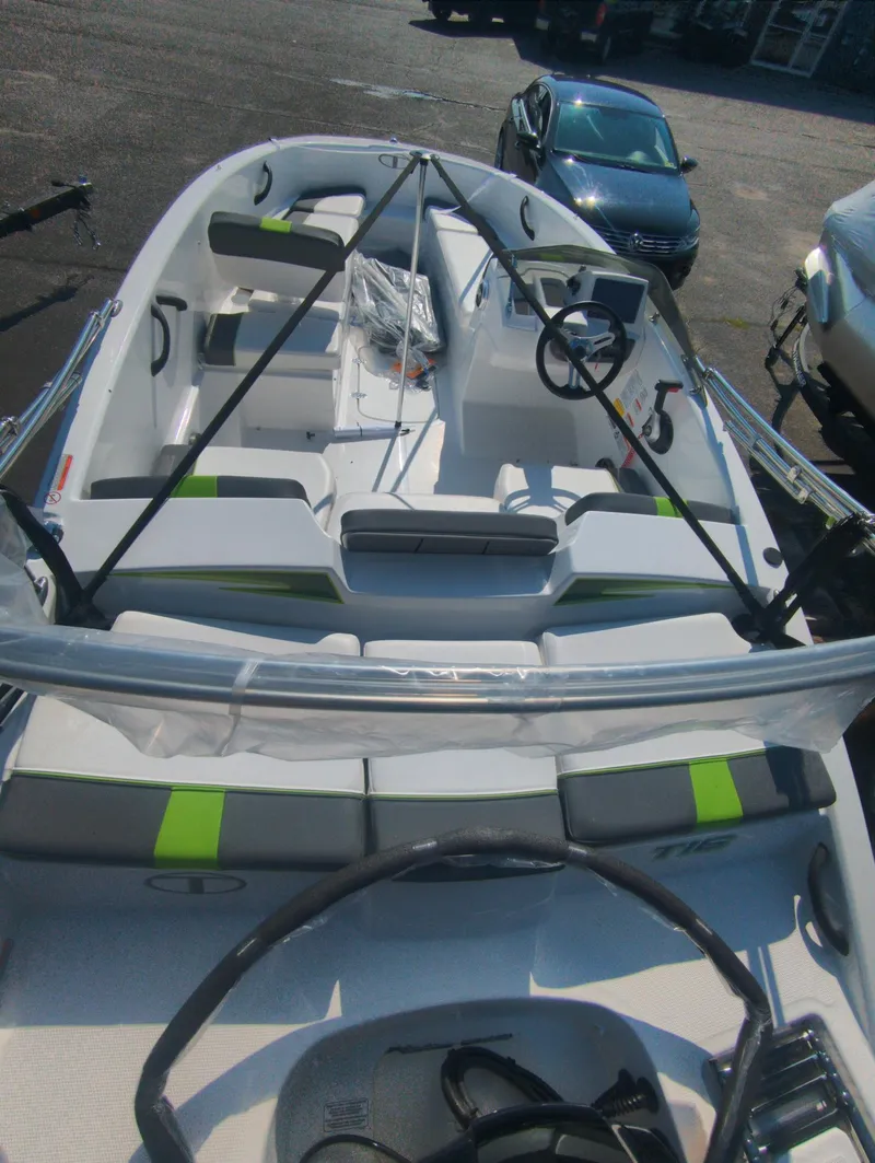 Slide: The Image of 2024 Tahoe T16 boat interior with seating and steering wheel, parked outdoors. - 8