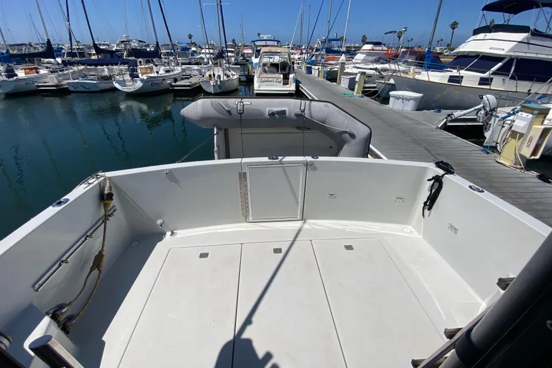 Slide: The Image of 1988 Chris-Craft 320 Amerosport Sedan docked at marina, featuring spacious deck area. - 10