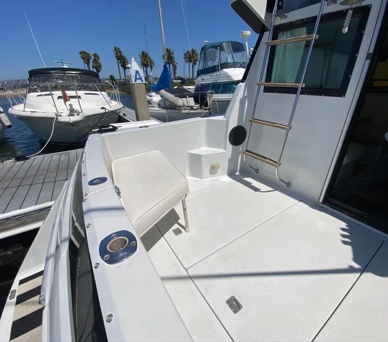 Slide: The Image of 1988 Chris-Craft 320 Amerosport Sedan docked, featuring spacious deck and ladder. - 16