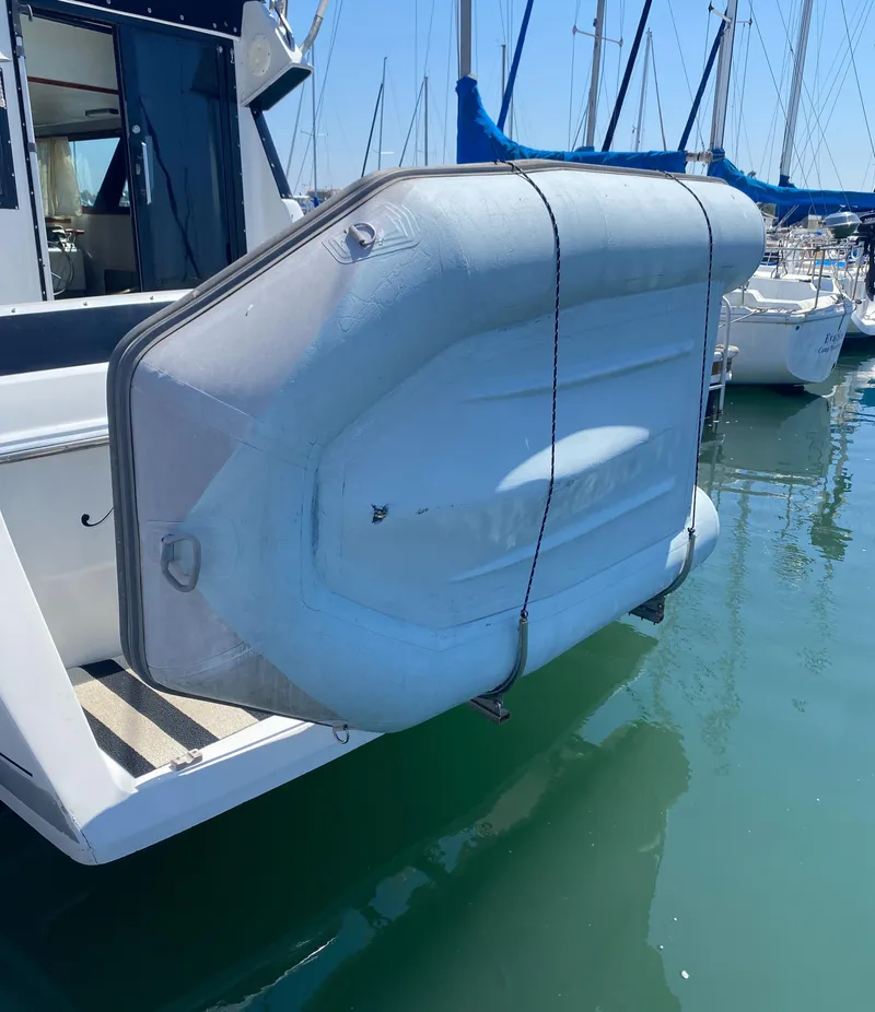 Slide: The Image of 1988 Chris-Craft 320 Amerosport Sedan with inflatable boat on stern, docked in marina. - 19