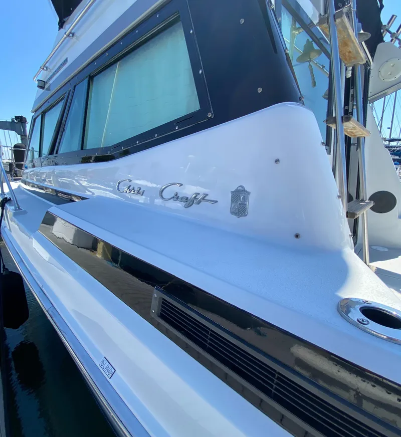 Slide: The Image of 1988 Chris-Craft 320 Amerosport Sedan boat docked, showcasing sleek design and branding. - 21