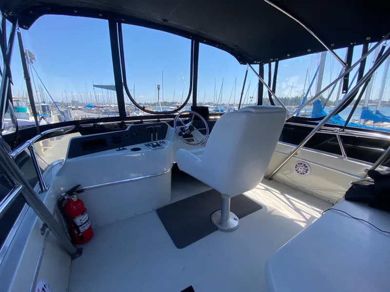 Slide: The Image of 1988 Chris-Craft 320 Amerosport Sedan cockpit with steering wheel and marina view. - 25