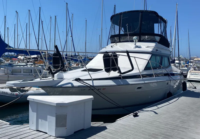 Slide: The Image of 1988 Chris-Craft 320 Amerosport Sedan docked at marina with sailboats. - 3
