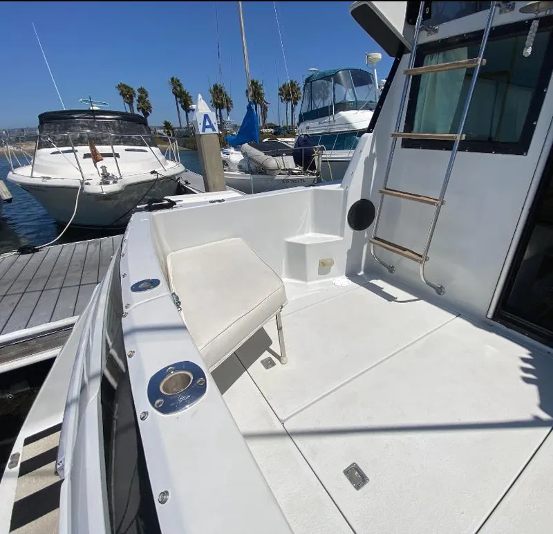 Slide: The Image of 1988 Chris-Craft 320 Amerosport Sedan docked, featuring spacious deck and seating area. - 4