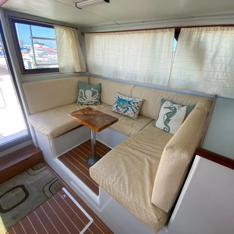 Slide: The Image of 1988 Chris-Craft 320 Amerosport Sedan interior with cozy seating and nautical-themed pillows. - 41