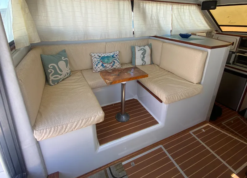 Slide: The Image of 1988 Chris-Craft 320 Amerosport Sedan interior with cozy seating and nautical-themed pillows. - 42
