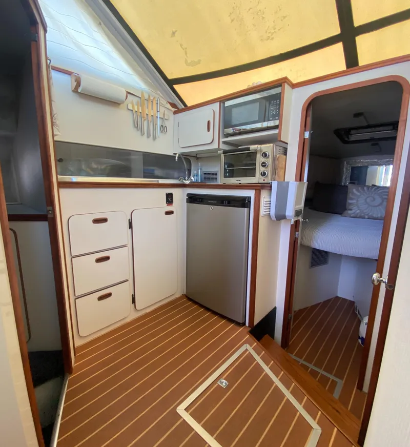 Slide: The Image of 1988 Chris-Craft 320 Amerosport Sedan interior kitchen with wood flooring and modern appliances. - 45
