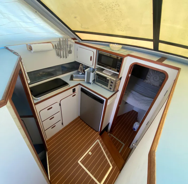 Slide: The Image of 1988 Chris-Craft 320 Amerosport Sedan kitchen with compact appliances and wood flooring. - 46