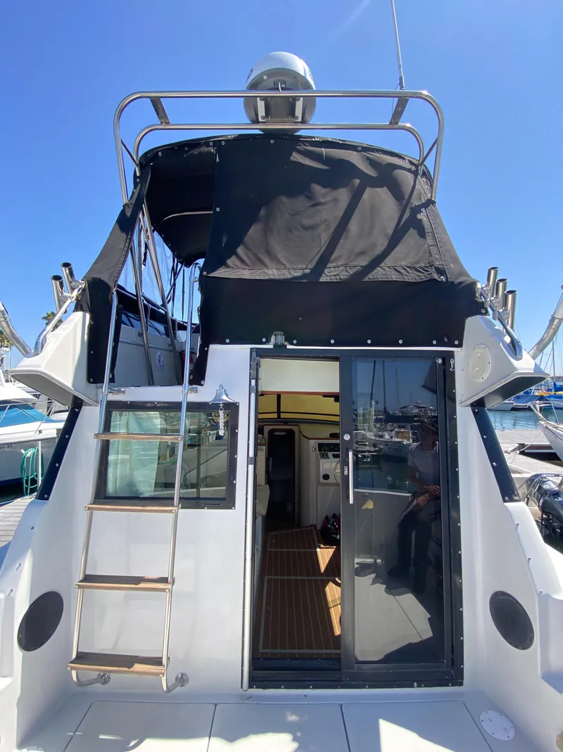 Slide: The Image of 1988 Chris-Craft 320 Amerosport Sedan boat with black canopy and ladder. - 5