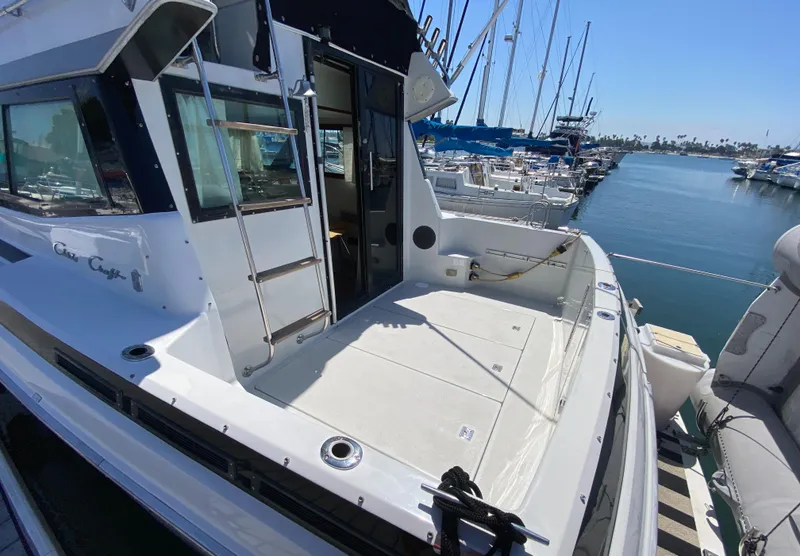 Slide: The Image of 1988 Chris-Craft 320 Amerosport Sedan docked at marina, spacious deck view. - 7