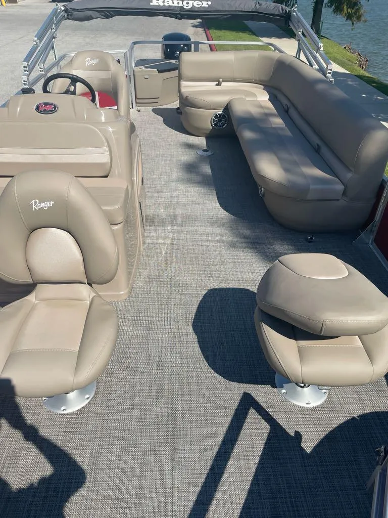 Slide: The Image of 2024 Ranger Reata 200F boat interior with beige seating and carpet flooring. - 3