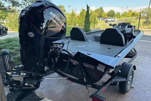 Slide: The Image of 2025 Tracker Pro Team 175 boat with Mercury engine, parked outdoors. - 2