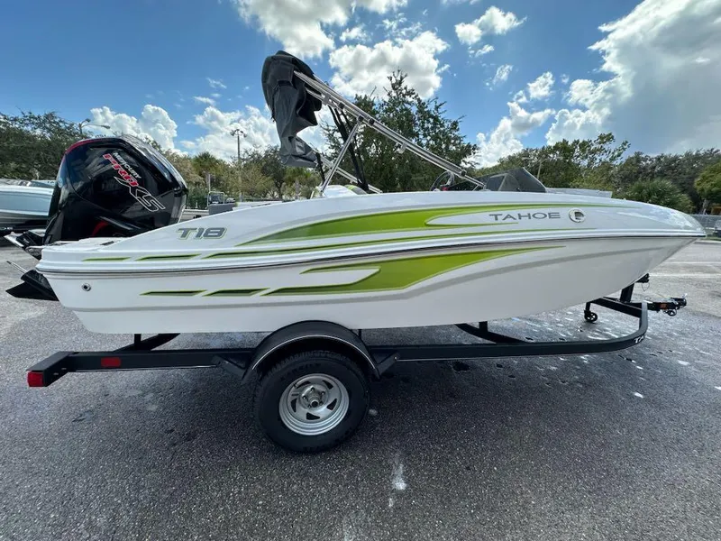 Slide: The Image of 2024 Tahoe T18 boat on trailer, featuring green accents and outboard motor. - 1