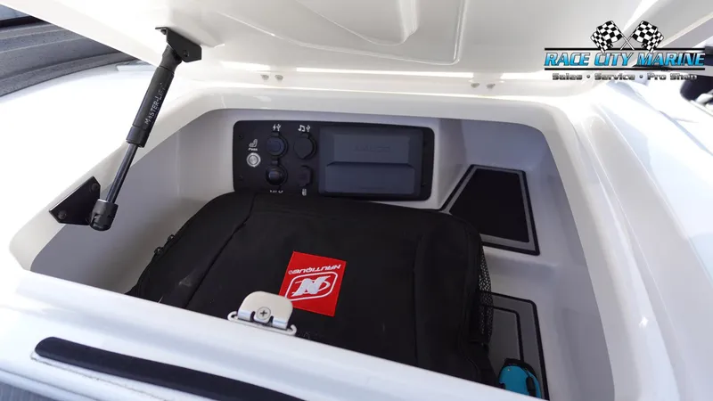 Slide: The Image of 2020 Nautique Super Air Nautique G23 storage compartment with control panel and equipment. - 30
