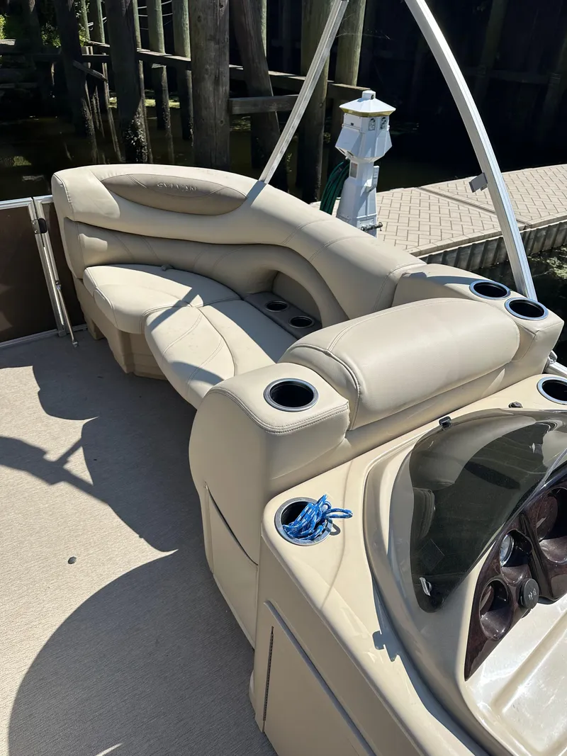 Slide: The Image of 2019 Sylvan Mirage 8522 LZ boat interior with beige seating and cup holders. - 10