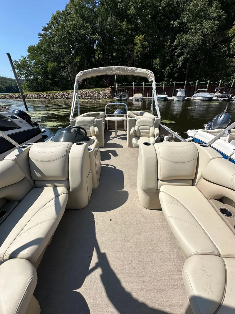 Slide: The Image of 2019 Sylvan Mirage 8522 LZ pontoon boat with beige seating, docked by a lake. - 11