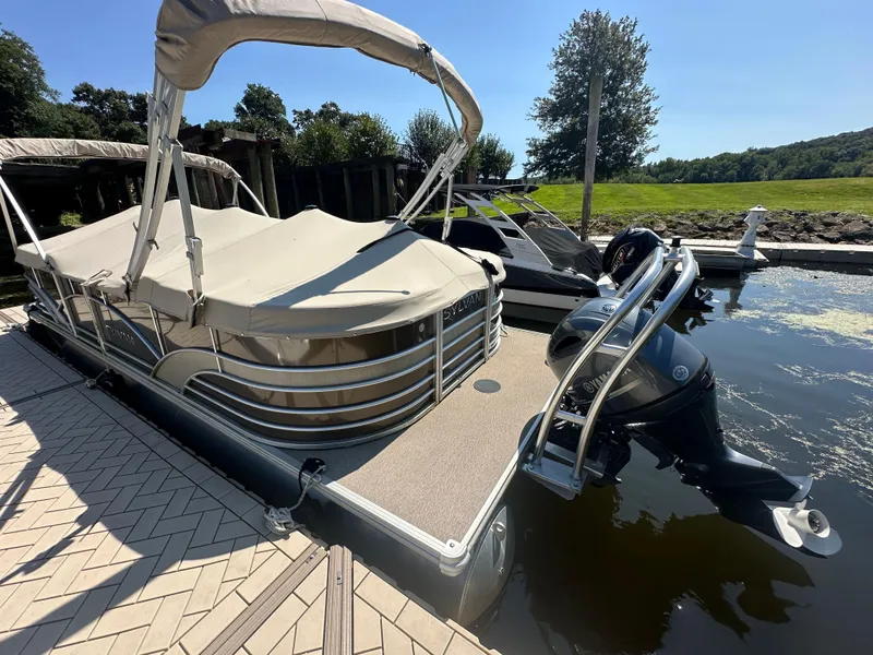 Slide: The Image of 2019 Sylvan Mirage 8522 LZ pontoon boat docked with canopy and outboard motor. - 17