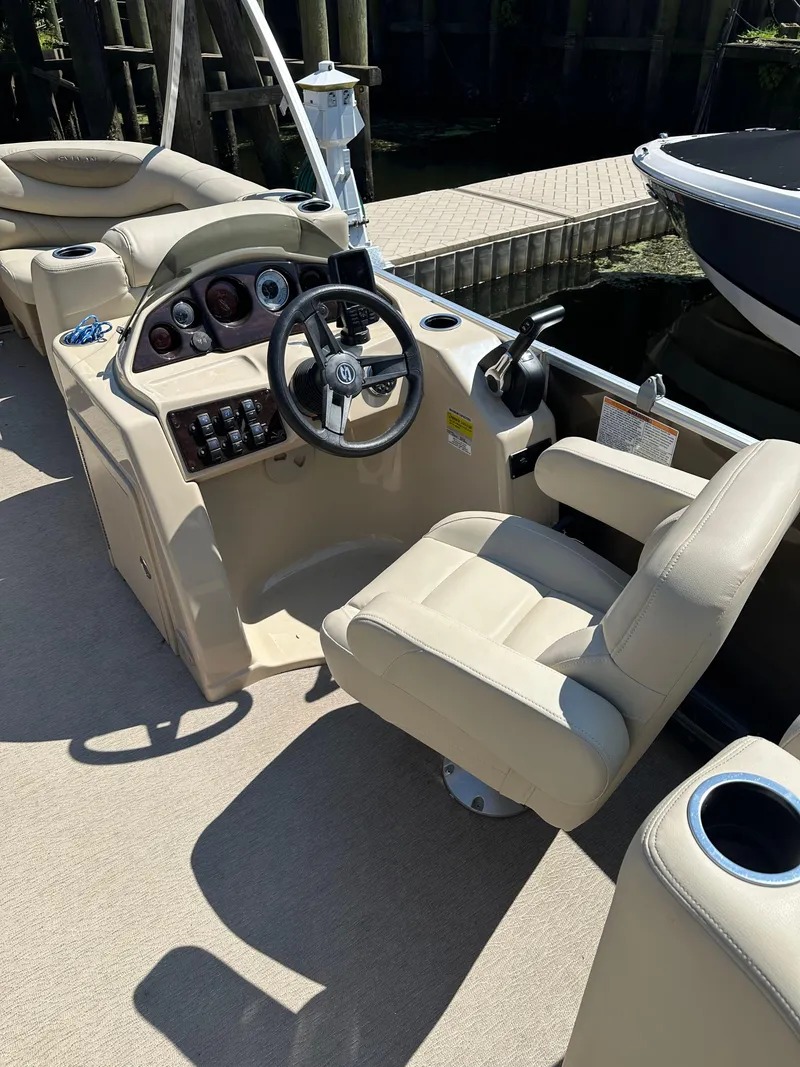 Slide: The Image of 2019 Sylvan Mirage 8522 LZ boat interior with steering console and seating. - 4