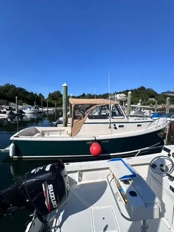 Slide: The Image of 1999 Atlas Boat Works Acadia 25 docked in a marina under clear blue skies. - 1