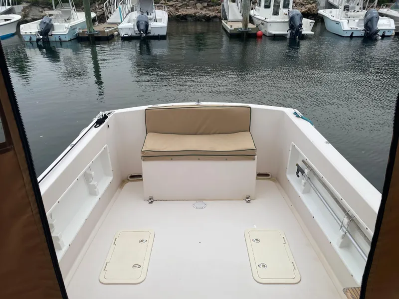 Slide: The Image of 1999 Atlas Boat Works Acadia 25, spacious deck with seating, docked in marina. - 12