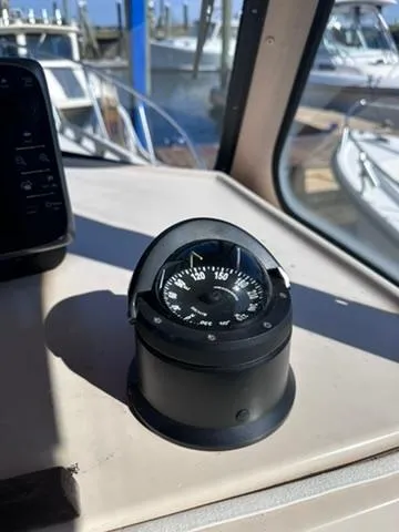 Slide: The Image of Compass on 1999 Atlas Boat Works Acadia 25, docked with other boats in background. - 21