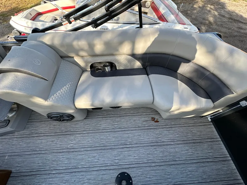 Slide: The Image of Luxurious seating on 2022 Premier 230 SunSation RF pontoon boat, featuring cup holders and speakers. - 14