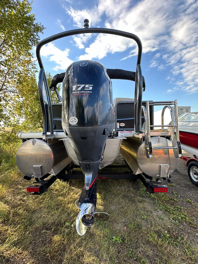 Slide: The Image of 2022 Premier 230 SunSation RF pontoon boat with powerful 175 HP engine, parked outdoors. - 15