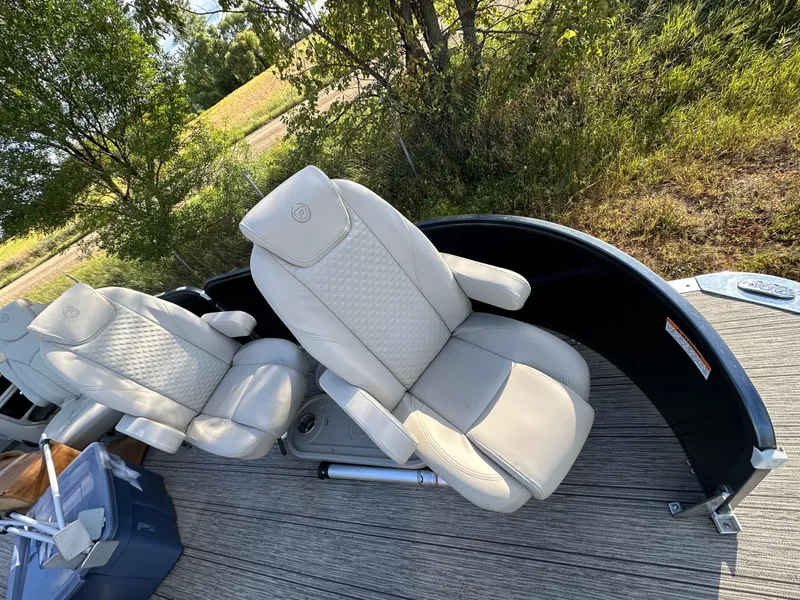 Slide: The Image of 2022 Premier 230 SunSation RF boat seats with beige upholstery on a sunny day. - 3