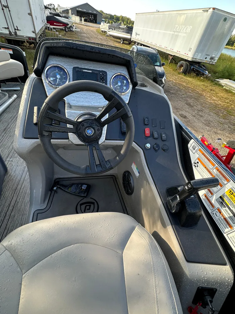 Slide: The Image of 2022 Premier 230 SunSation RF boat dashboard with steering wheel and controls. - 5