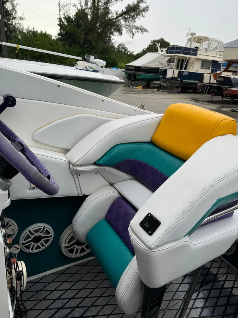 Slide: The Image of 1997 Hustler 32 boat interior with colorful seats and steering wheel. - 3