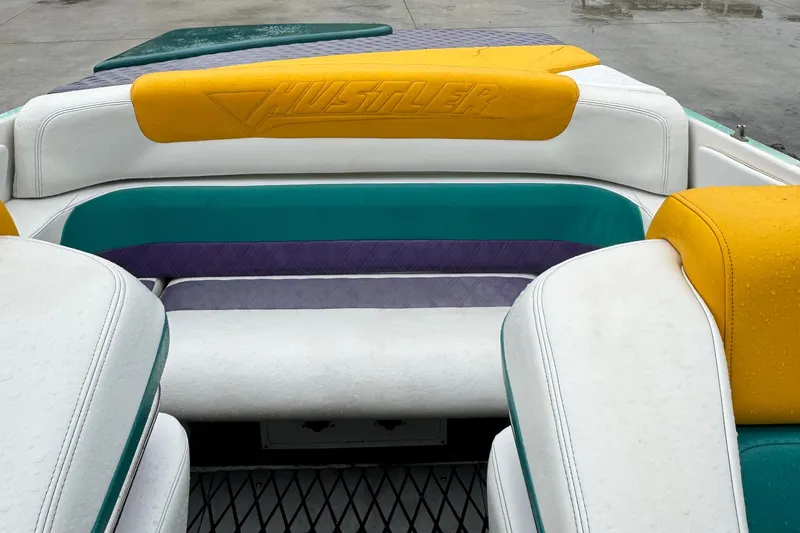 Slide: The Image of Interior of a 1997 Hustler 32 boat with colorful seating. - 5
