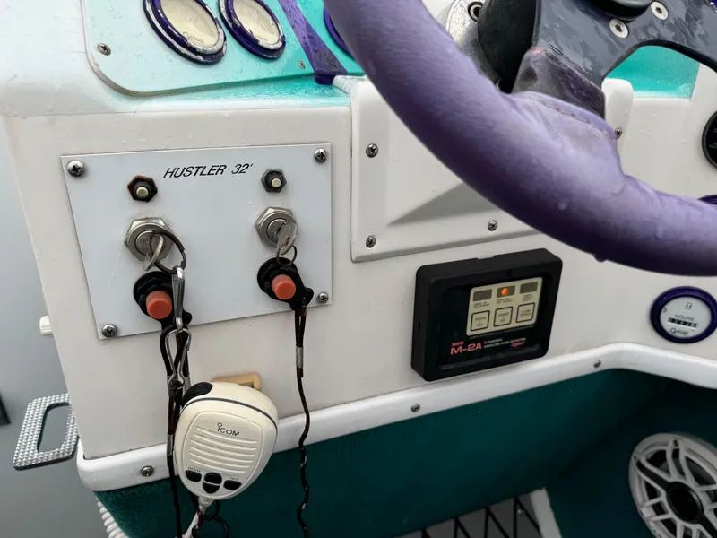Slide: The Image of Control panel of a 1997 Hustler 32 boat with steering wheel and radio. - 6