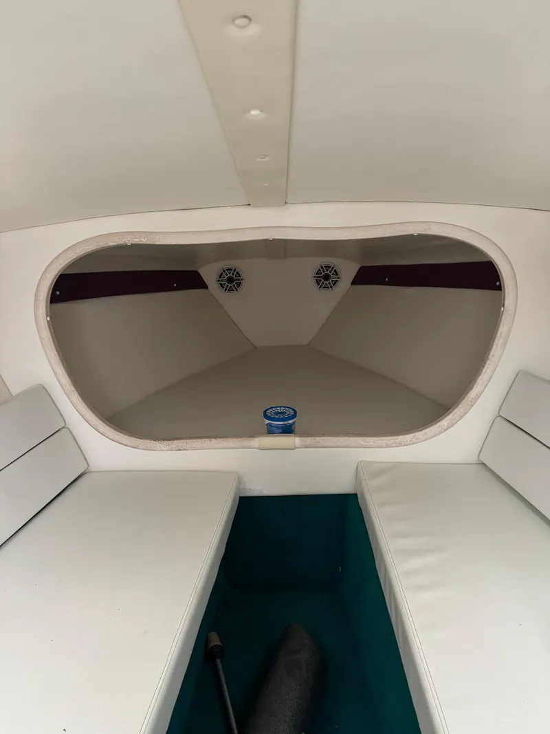 Slide: The Image of Interior of 1997 Hustler 32 boat with white seating and speakers. - 8