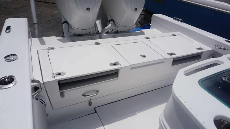 Slide: The Image of 2025 Everglades 273 CC boat deck with storage compartments and dual engines. - 12