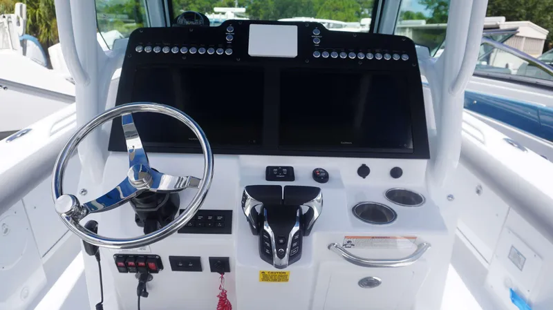 Slide: The Image of 2025 Everglades 273 CC boat helm with steering wheel and dual displays. - 14