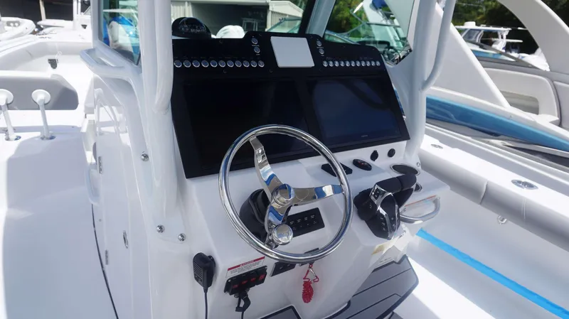 Slide: The Image of 2025 Everglades 273 CC boat console with steering wheel and modern controls. - 15