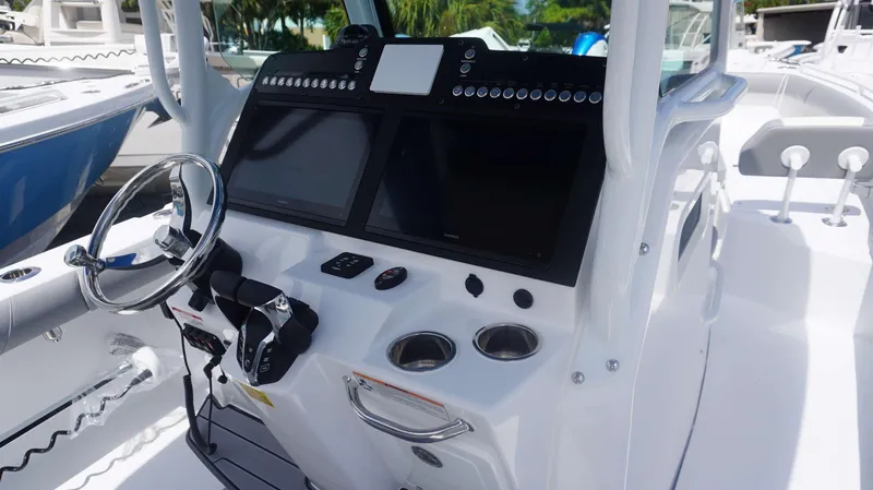 Slide: The Image of 2025 Everglades 273 CC boat dashboard with dual screens and steering wheel. - 16