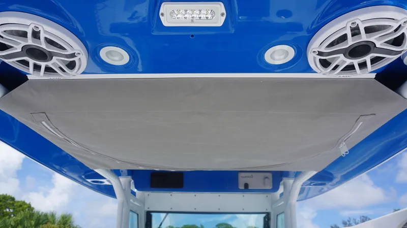 Slide: The Image of 2025 Everglades 273 CC boat with blue canopy, speakers, and LED lights. - 17