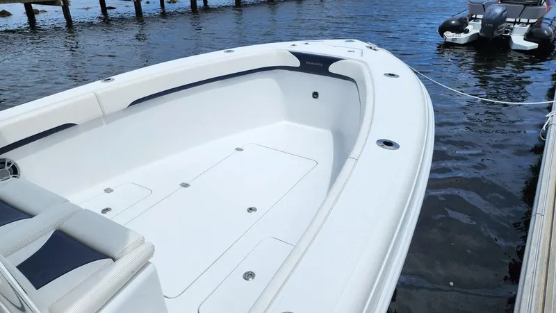 Slide: The Image of 2015 Bluewater 2550 boat docked on calm water, showcasing spacious deck design. - 10